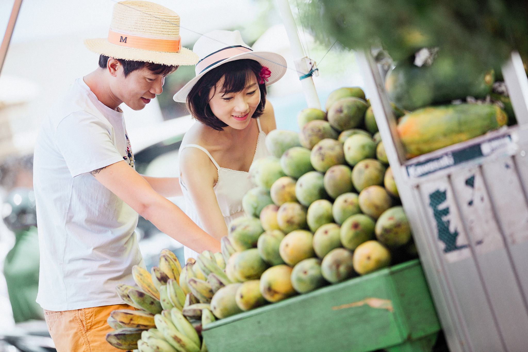 Picture of a man and woman admiring fruits in a fruit stand
